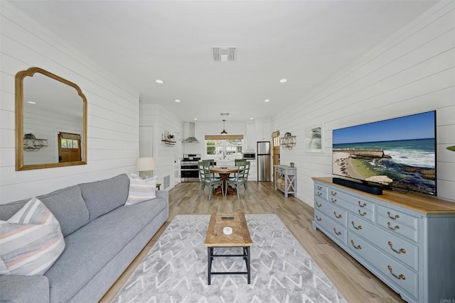 living room with wood walls and light wood-type flooring