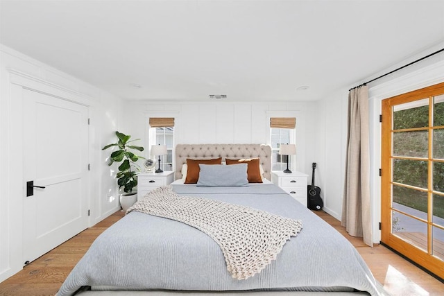 bedroom featuring access to exterior and light wood-type flooring