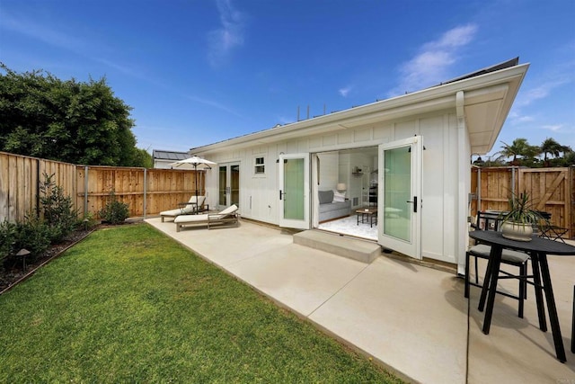 back of property featuring a yard and a patio area