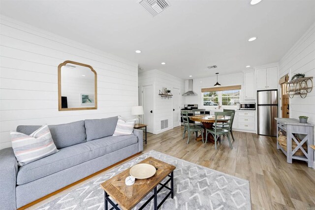 living room with wood walls and light hardwood / wood-style flooring