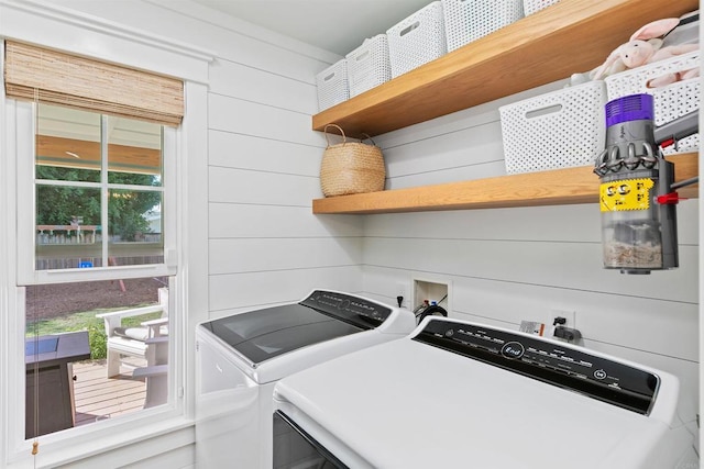 laundry area with separate washer and dryer and wooden walls