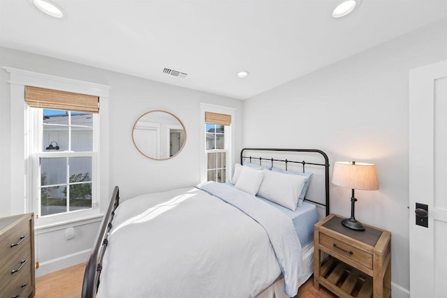 bedroom featuring multiple windows and light hardwood / wood-style floors