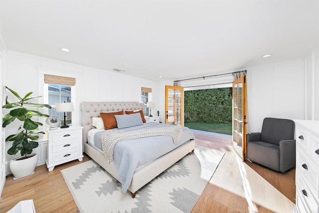 bedroom with multiple windows, light hardwood / wood-style floors, and access to exterior