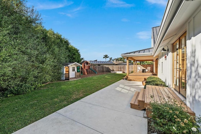 exterior space featuring a playground, a patio area, a shed, and a deck