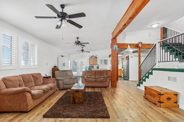 living room featuring vaulted ceiling with beams, light hardwood / wood-style floors, and french doors