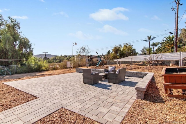 view of patio with a playground and an outdoor hangout area