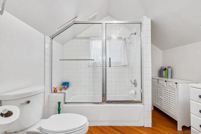 full bathroom featuring toilet, vaulted ceiling, vanity, hardwood / wood-style flooring, and enclosed tub / shower combo