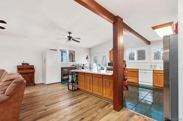 kitchen featuring white appliances, light hardwood / wood-style flooring, ceiling fan, vaulted ceiling with beams, and kitchen peninsula