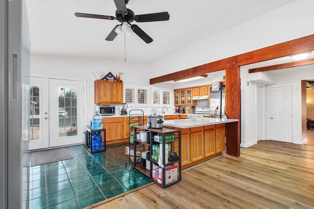 kitchen featuring appliances with stainless steel finishes, ceiling fan, kitchen peninsula, dark wood-type flooring, and french doors