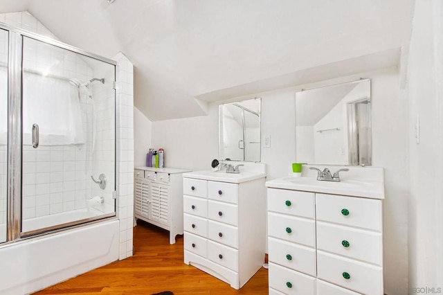 bathroom with enclosed tub / shower combo, vanity, vaulted ceiling, and hardwood / wood-style floors