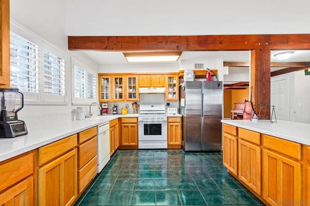 kitchen featuring sink, white appliances, and dark tile patterned floors