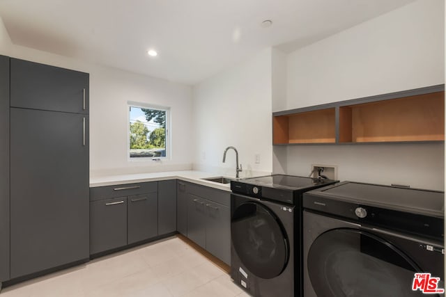 laundry room featuring cabinets, sink, and washer and dryer