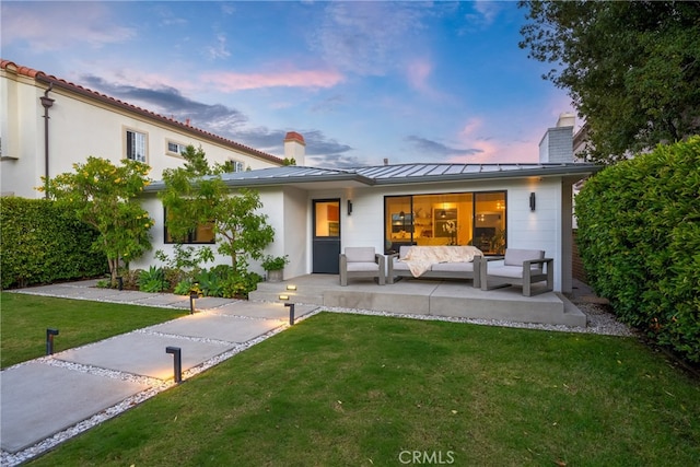 view of front of house featuring a yard, an outdoor living space, and a patio area