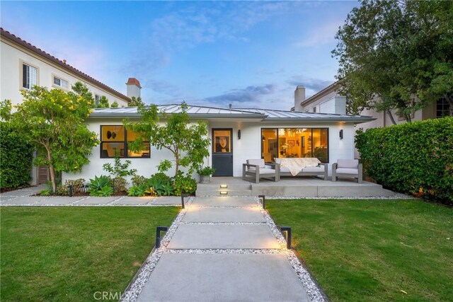 view of front of home with a patio, a yard, and outdoor lounge area