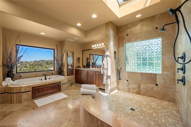 bathroom featuring a skylight, vanity, shower with separate bathtub, and tile patterned flooring