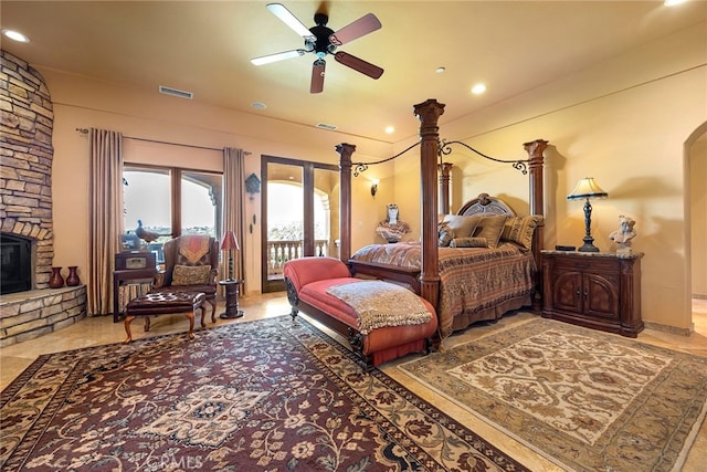 bedroom with ceiling fan, access to exterior, and a fireplace