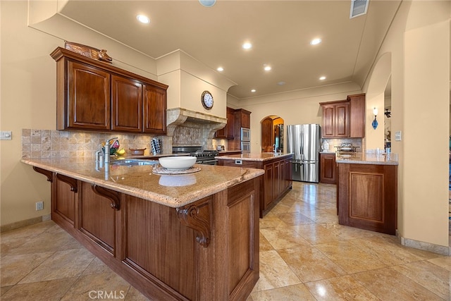 kitchen with appliances with stainless steel finishes, backsplash, sink, and kitchen peninsula