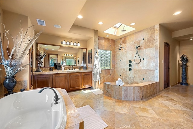 bathroom with a skylight, vanity, and plus walk in shower