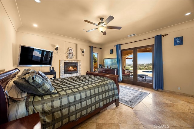 bedroom featuring a fireplace, ceiling fan, and access to exterior