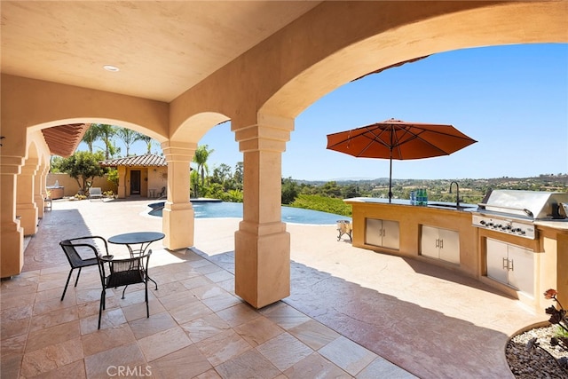 view of patio with exterior kitchen, sink, and a grill