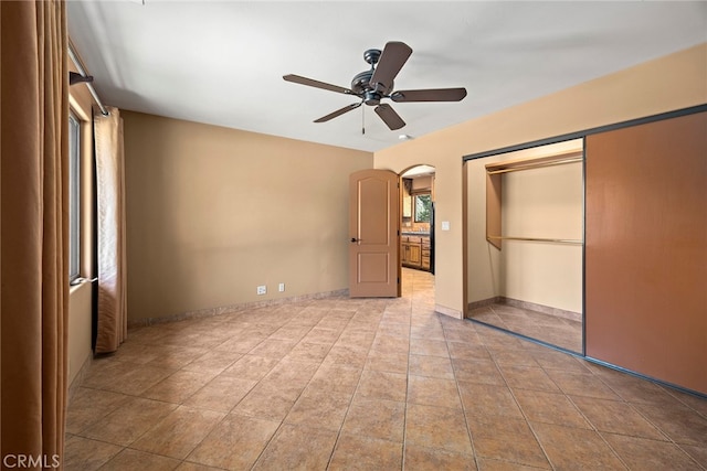 unfurnished bedroom featuring light tile patterned floors, ceiling fan, and a closet