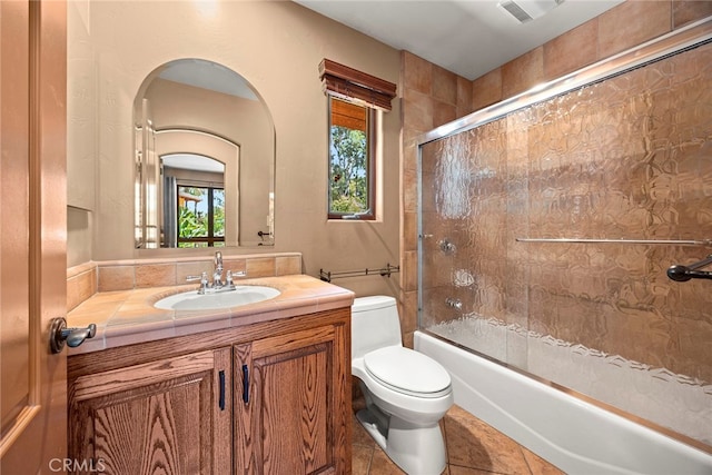 full bathroom featuring enclosed tub / shower combo, tile patterned flooring, vanity, and toilet