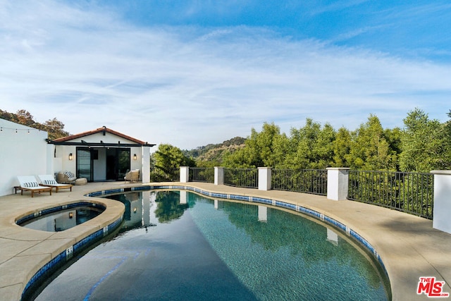 view of swimming pool featuring an in ground hot tub and a patio area