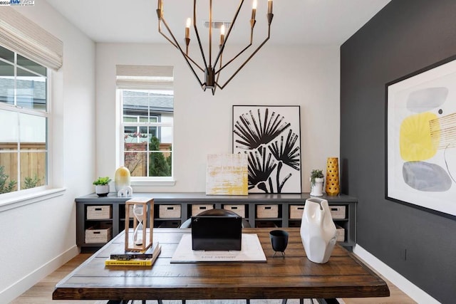 home office featuring a notable chandelier and light wood-type flooring