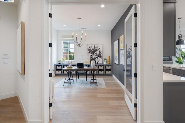 dining space with light hardwood / wood-style flooring and a notable chandelier