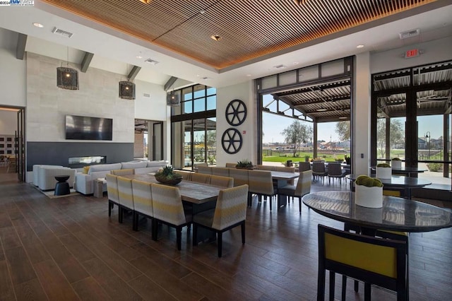 dining area with dark wood-type flooring and a high ceiling