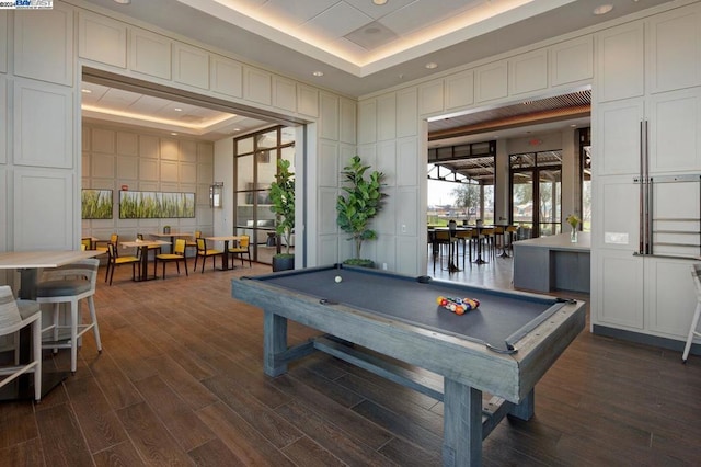 game room with a raised ceiling, dark hardwood / wood-style floors, and pool table