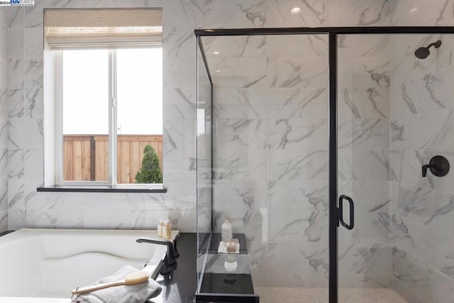 bathroom with independent shower and bath, tile walls, and a wealth of natural light