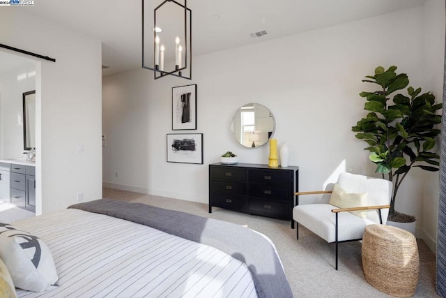 bedroom with ensuite bath, light carpet, and an inviting chandelier