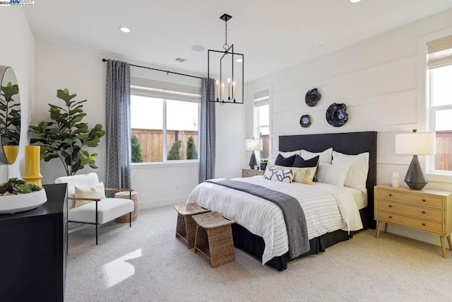 bedroom featuring light colored carpet and an inviting chandelier