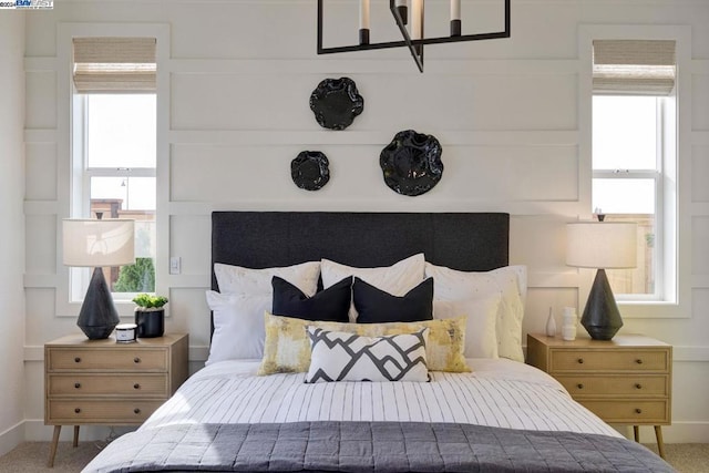 carpeted bedroom with a notable chandelier