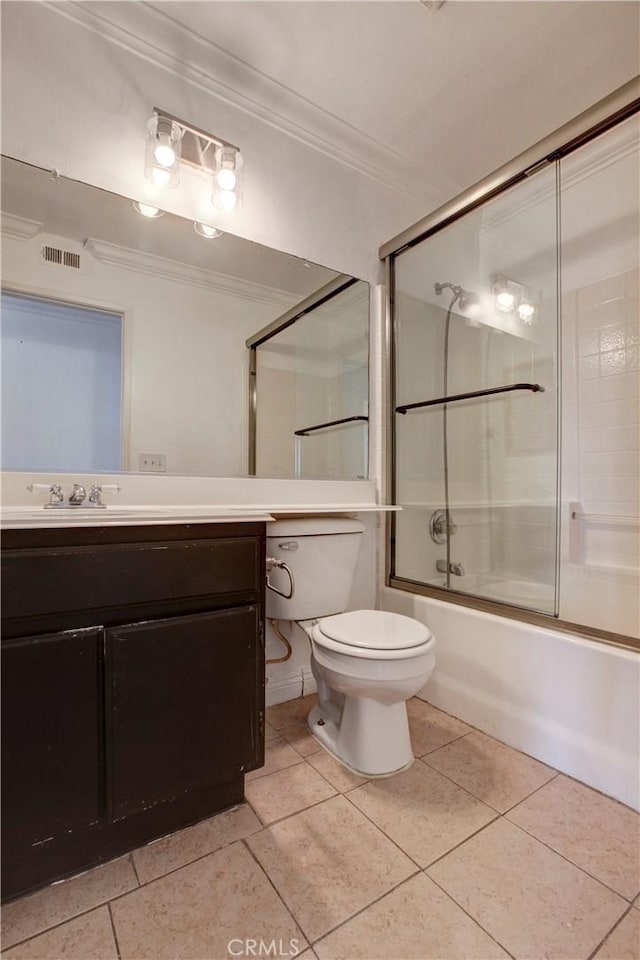 full bathroom with combined bath / shower with glass door, ornamental molding, vanity, tile patterned flooring, and toilet