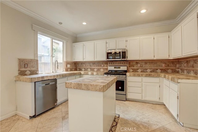 kitchen with white cabinets, decorative backsplash, a kitchen island, and stainless steel appliances