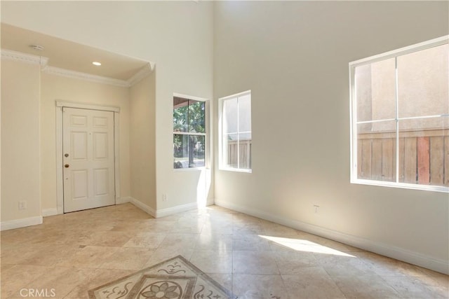 empty room featuring a high ceiling and ornamental molding