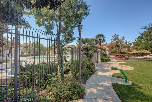 view of home's community featuring a lawn and a pool