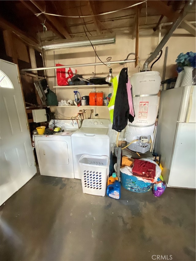 interior space featuring washer and clothes dryer, strapped water heater, and white fridge