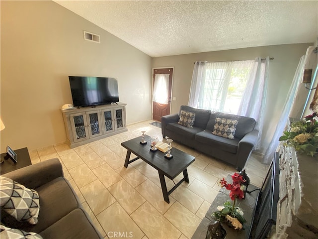 living room featuring a textured ceiling, vaulted ceiling, and light tile patterned floors