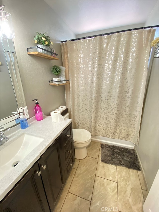 bathroom with tile patterned floors, curtained shower, vanity, and toilet