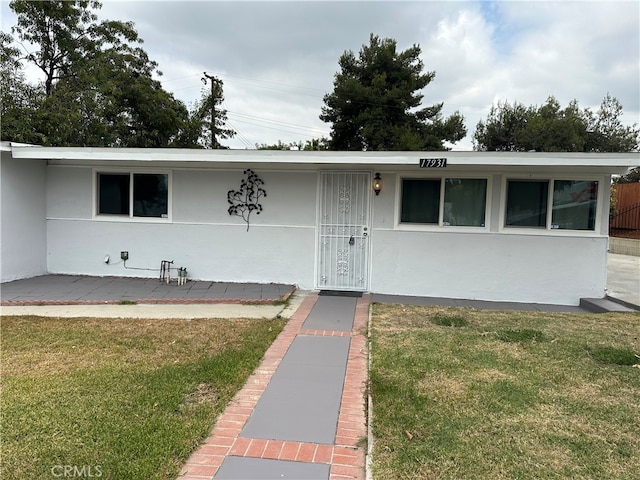 single story home featuring a front lawn