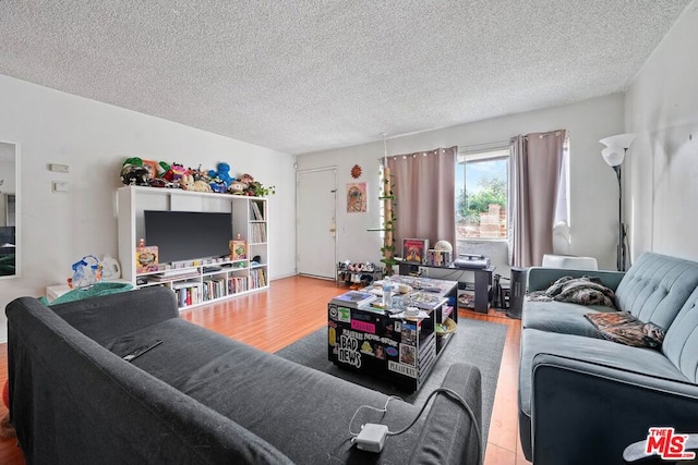 living room featuring wood-type flooring and a textured ceiling