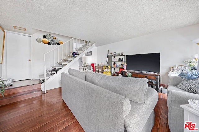 living room featuring a textured ceiling and dark hardwood / wood-style floors