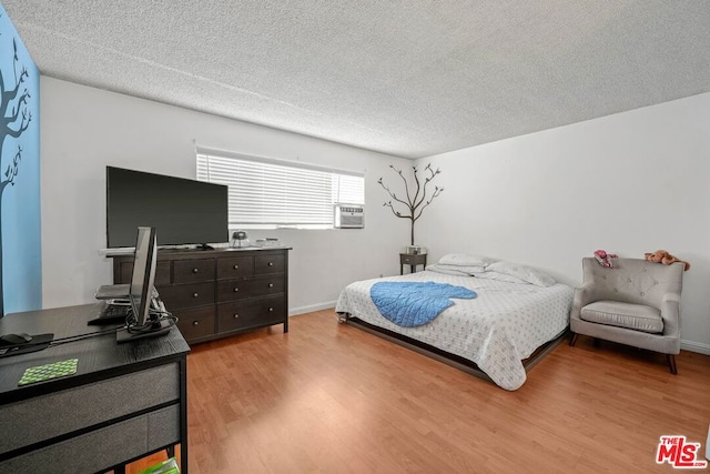 bedroom with a textured ceiling and light wood-type flooring