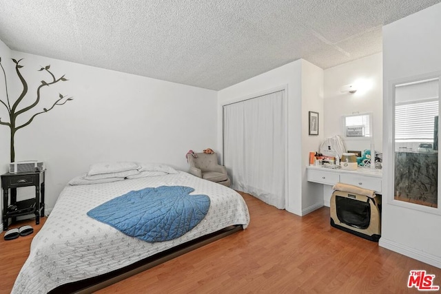 bedroom featuring a textured ceiling, a closet, and hardwood / wood-style flooring