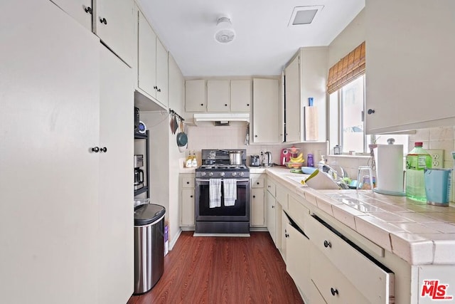 kitchen featuring dark hardwood / wood-style flooring, tile counters, gas stove, and tasteful backsplash