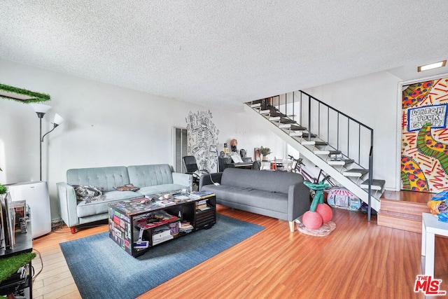 living room featuring a textured ceiling and hardwood / wood-style floors