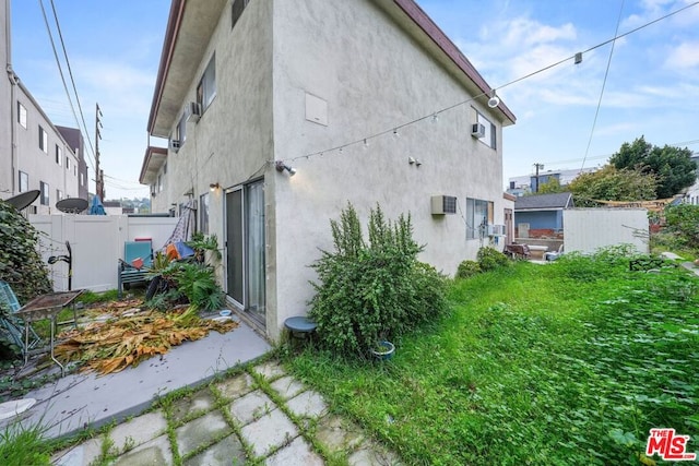 rear view of property featuring a lawn and a storage shed